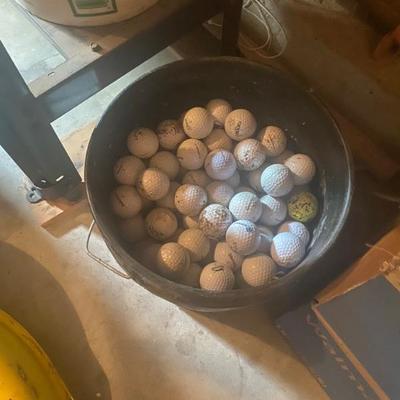 Golf balls in a bucket in the garage