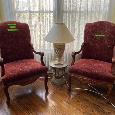 a pair of Martha Washington style armchairs, richly carved with dark red upholstery