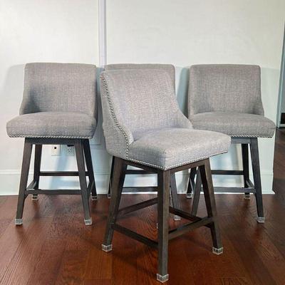 (4PC) GRAY BARSTOOLS | Counter height bar stools with swiveling seats with grey upholstered seats on dark wood bases; seat height 25 in....