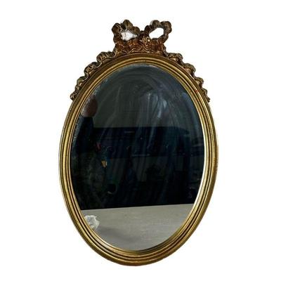 OVAL MIRROR IN GILT FRAME | Oval mirror with ribbon and bow carving on top in gilt frame. - w. 15 x h. 23 in 
