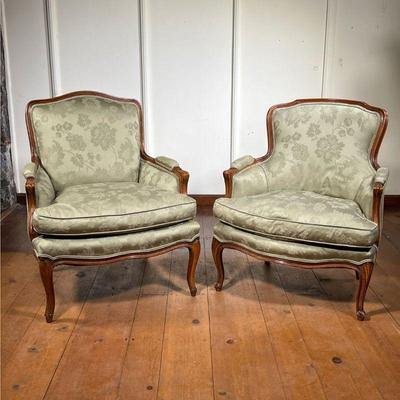 (2pc) Pair Louis XV Style Bergere Chairs | Pair of French style carved armchairs upholstered in a soft green satin fabric with a floral...