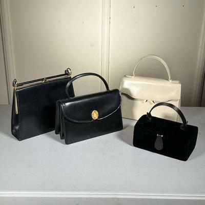 (4pc) Saks Fifth Ave Handbags & Purses | Two black leather Saks Fifth Avenue purses, a white Saks purse, and one velvet-lined cosmetics...