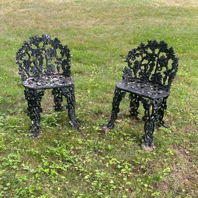 Pair Wrought Iron Chairs | Two small wrought iron garden chairs with grapevine motifs composing the openwork seats, seat backs, and legs....