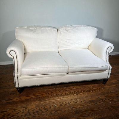Ralph Lauren Loveseat | With white fabric upholstery, brass tacks along the bottom and scrolled arms. - l. 66 x w. 42 x h. 30 in 
