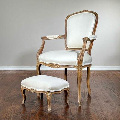 (2pc) Bergere Chair & Ottoman | A French Louis XV-style bergere arm chair with white upholstery and matching ottoman, carved wood frames....