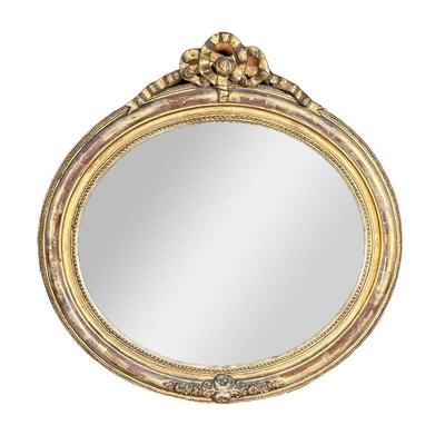 ROUND GILT MIRROR | Oval-shaped mirror with floral relief on bottom and carved ribbon bow on top. - l. 21 x h. 21 in 