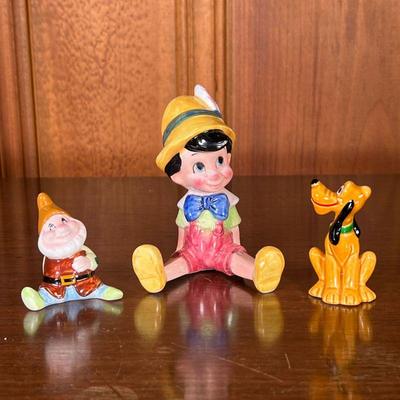 DISNEY CERAMIC FIGURINES | Includes: Pinocchio, Happy (from Snow White), and Pluto the dog. - l. 3.25 x w. 2.5 x h. 4.25 in (Pinocchio) 