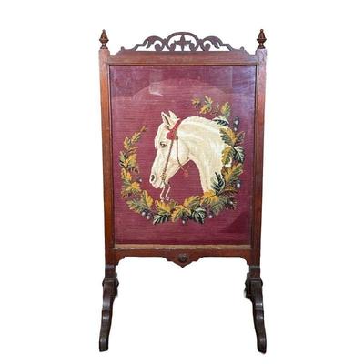 HORSE NEEDLEPOINT IN ANTIQUE FRAME | Carved antique frame with scroll work on top framing horse needlepoint with wreath around its head....