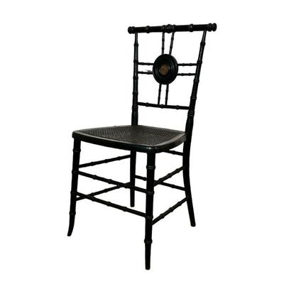 BLACK CANE CHAIR | Black cane chair with spindle legs and back with medallion in center depicting a riverside oil painting. - l. 16 x w....