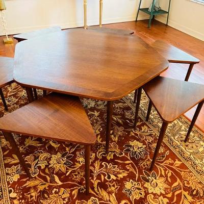 Hexagonal Coffee Table with six triangular nesting snack tables that tuck underneath in dedicated integrated slots.
Design attributed to...