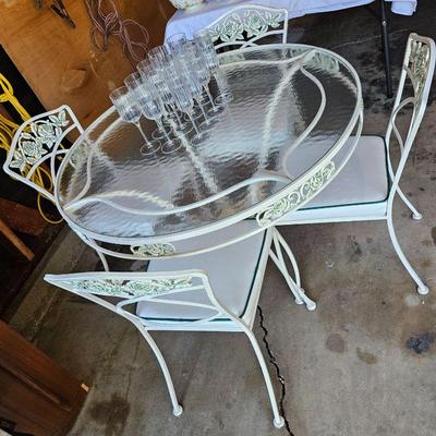 Vintage wrought iron & glass patio table & chairs.