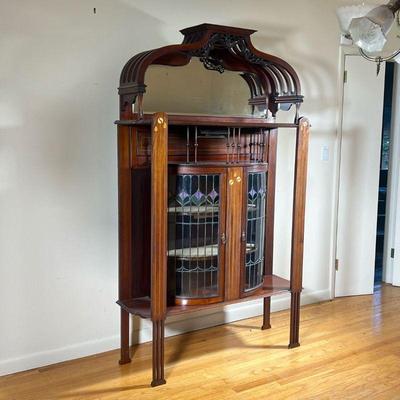 CARVED & INLAID ART NOUVEAU CABINET | Carved arch top gallery with pierced openwork whiplash devices, over a shelf with mirrored...