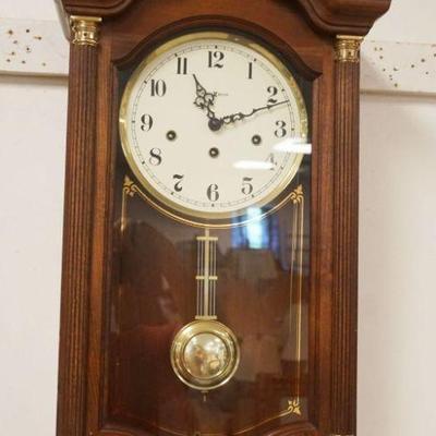 1153	HOWARD MILLER WALL CLOCK IN CHERRY CASE, APPROXIMATELY 7 IN X 13 IN X 25 IN HIGH
