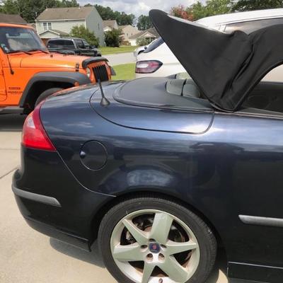The 2004 Saab model 9-3 has 124,120 miles, Vin # Y53FD79Y146002027 is navy blue with a black convertible top, white leather upholstery...