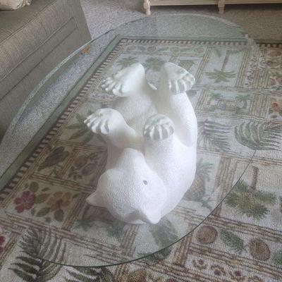 Glass top coffee table with a polar  bear on its back, holding the glass top