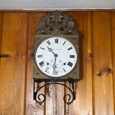 FRENCH WAG ON THE WALL CLOCK | French Clock with a porcelain face, Roman numerals, no case. Has a gilded pressed tin crest of flowers in...