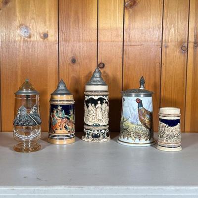 (5PC) GERMAN STEINS | Lot Includes: (1) Amber Painted Glass with relief. (1) Relief Figures on green marked â€œGermany 1416â€ (1)...