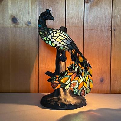 PEACOCK IN STAINED GLASS | Peacock has small bulb to illuminate the fowl. On tree-shaped base. - l. 9 x w. 8 x h. 16.5 in 
