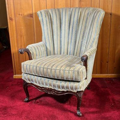 QUEEN ANNE ARMCHAIR | Vintage Upholstered Armchair with carved Queen Anne style arms and cabriole legs. Fabric is a mixture of colors...