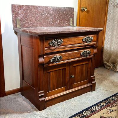 VICTORIAN MARBLE TOP WASHSTAND | Marble top and backsplash of brown marble. Backsplash connected by a brass hinge to marble top. Two...