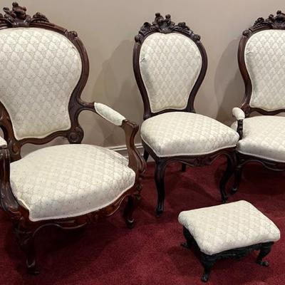 Antique Victorian Four Piece Walnut Parlor Set. This lovely set includes a gentlemen's chair, ladies chair, foot rest and an additional...
