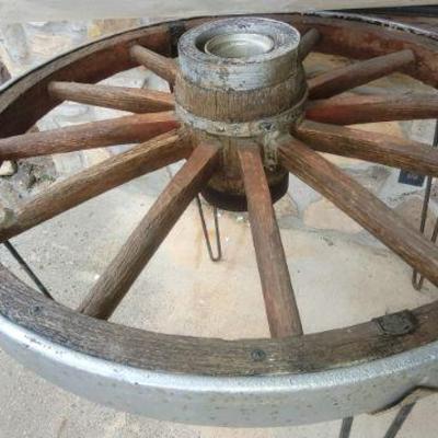 Wooden Wagon wheel table. Has a plastic top.
