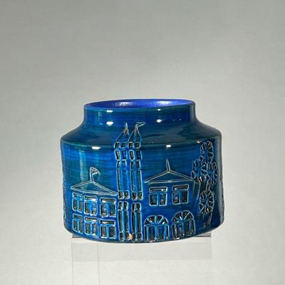 SMALL BLUE GLAZED POTTERY VESSEL | Small blue ceramic planter decorated with a town scene in relief, featuring buildings and trees....