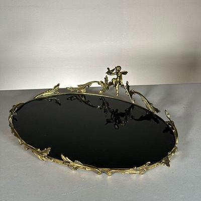 BLACK GLASS TRAY WITH ORNATE RIM | Shiny glass tray with ornate golden ring and cherub. - l. 17 x w. 13 in 