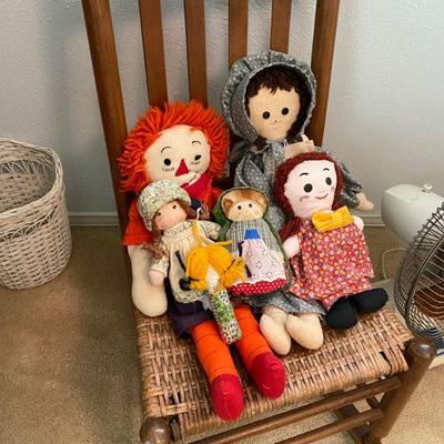 Antique rocker with rush seat with a collection of Rag Dolls