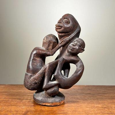HAND CARVED AFRICAN STATUE | Shows motherly figure holding two children. - l. 5 x w. 5 x h. 9 in 