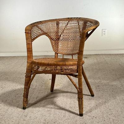 WICKER CHAIR | Antique woven wicker chair with a rounded back, armrests, and braided black accents. - l. 24 x w. 20 x h. 27.5 in 
