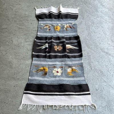 FLAT WOVEN MEXICAN MAT | Woven fabric in stripes of black, white, and blue, and decorated with decorated with birds and flowers in white...