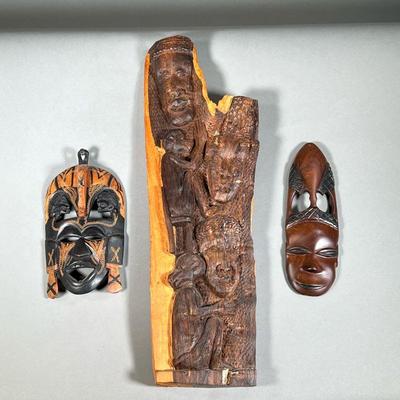 (3PC) AFRICAN WOOD CARVINGS | Three intricate wooden carvings, including two hand carved masks and larger wood carvings depicting faces...
