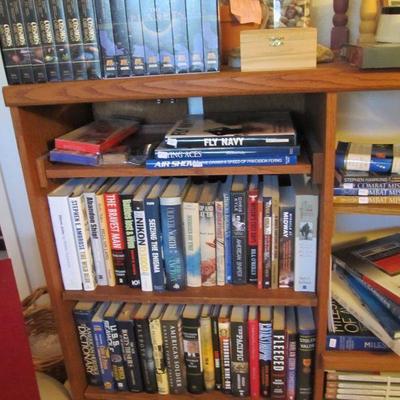 Wooden bookshelf storage is full of great books! Military history collector books, novels & more.