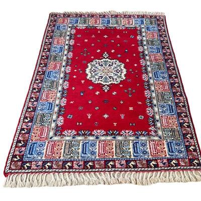 MOROCCAN CARPET | Central medallion on a red field with wide geometric border, worked in shades of red, blue, white, gray, and beige. -...