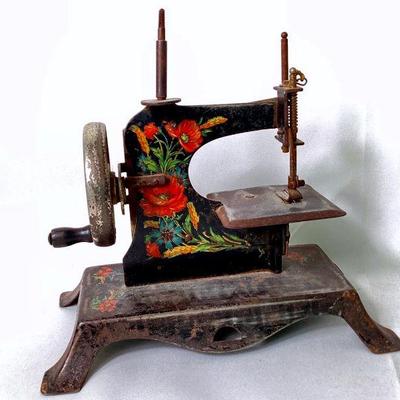 RIHI974 Vintage Toy Sewing Machine	Circa 1940 mini working metal sewing machine with floral decoration. Â 
