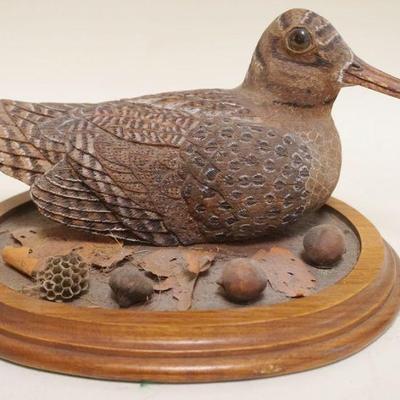 1128	CARVED BIRD W/GLASS EYES & PAINT ACCENTED FEATHERS ON WOOD BASE, APPROXIMATELY 9 IN X 8 IN X 6 IN HIGH
