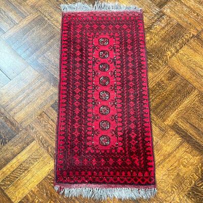RED GEOMETRIC RUG | Having 8 small medallions with geometric border on red ground. - l. 54 x w. 22 in 
