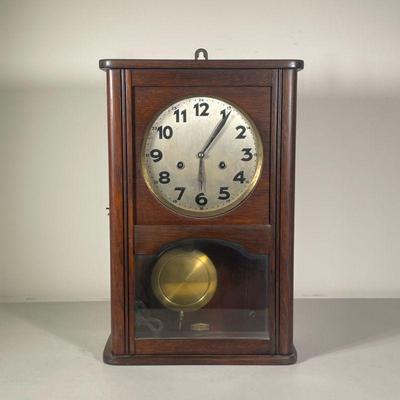 MAHOGANY WALL CLOCK | Mahogany clock with gilt border around face, both 12 and 24-hour time on face. - l. 11.5 x w. 5 x h. 17.5 in 