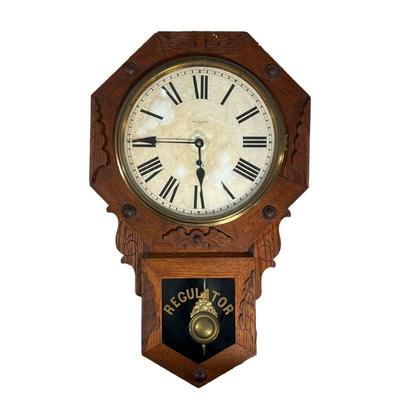 NEW HAVEN CARVED REGULATOR CLOCK | Carved oak wall clock with ornate brass wright made by New Haven Clock Co. - l. 17 x w. 5 x h. 27 in 