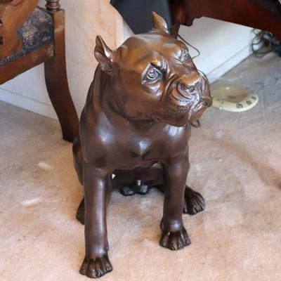 Life-size heavy bronze sculpture of a dog (possibly a bulldog, rottweiler, or pitbull).