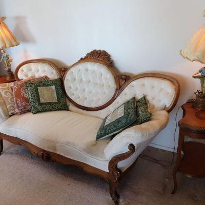 Antique Victorian carved wood and white upholstered sofa. Antique kidney shaped wood side tables. Pair of antique statue lamps. 