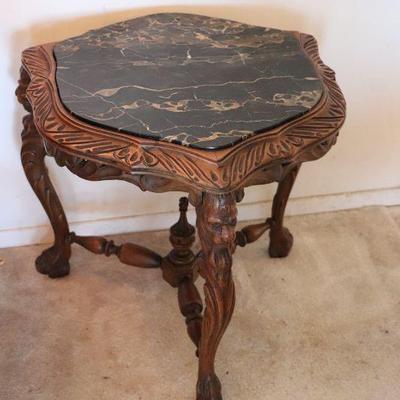 Beautiful antique carved wood and black marble accent side table in unique shield or crest shape. 