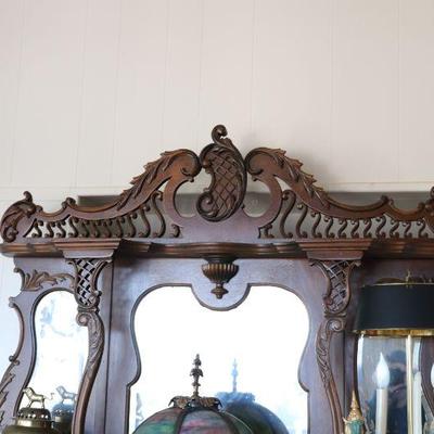 Gorgeous antique display cabinet with mirrors and detailed carvings. Antique art deco lamp. Vintage decor. 