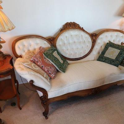 Antique Victorian carved wood and white upholstered sofa. Antique kidney shaped wood side tables. Pair of antique statue lamps. 