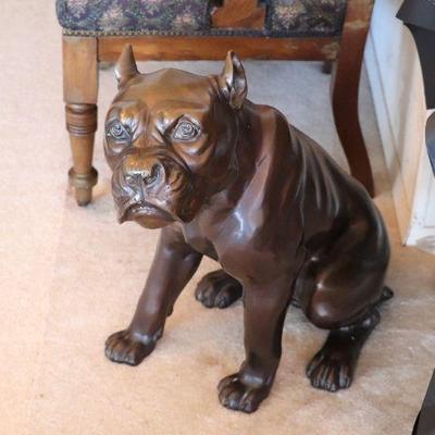 Life-size heavy bronze sculpture of a dog (possibly a bulldog, rottweiler, or pitbull).
