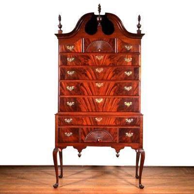 CHIPPENDALE FLAME MAHOGANY BONNET TOP HIGHBOY | With turned carved finials, open bonnet top, two carved fans, and beautifully figured...