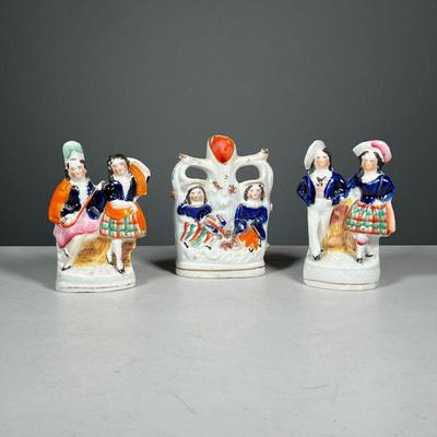 (3PC) STAFFORDSHIRE FIGURAL GROUPS | Including two figures of pairs of girls engaged in various activities, plus one spill vase with...
