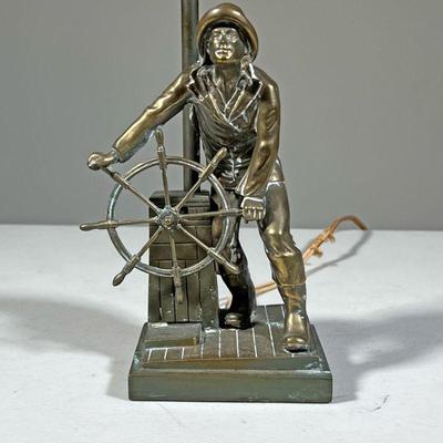 SHIP CAPTAIN LAMP | Brass table lamp in the form of a fisherman at the wheel. - l. 4.25 x w. 3.5 x h. 15.5 in (over harp) 
