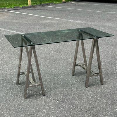CONTEMPORARY SAW HORSE DESK | Having a tempered glass top on chromed sawhorse form supports. - l. 56 x w. 28 x h. 30.5 in
